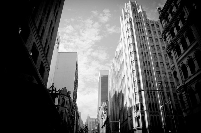 Monochrome cityscape with tall buildings and cloudy sky