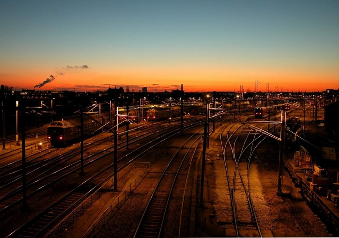 Train station at sunset with city skyline