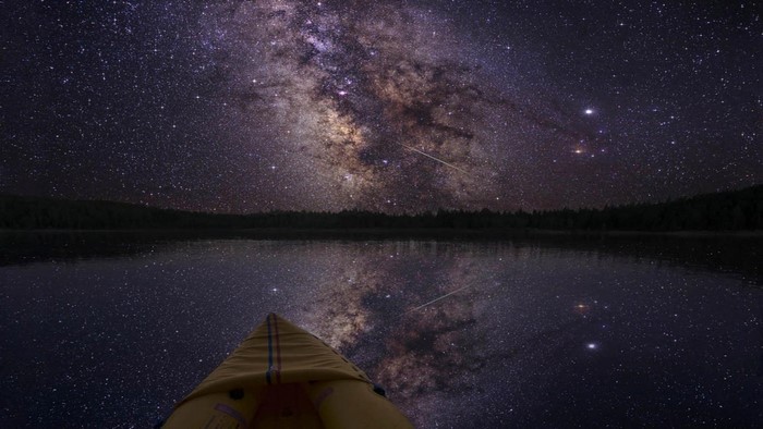 Milky Way reflection over lake from a boat