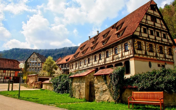 Half-timbered buildings in a rural village with a wooden bench