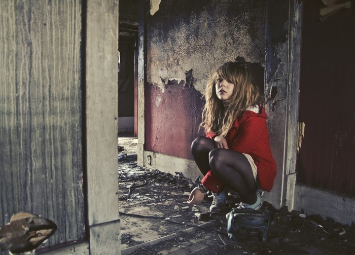 Young woman in red coat in abandoned building