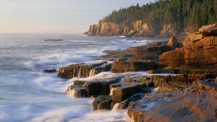 Rocky coast with waves crashing at sunrise