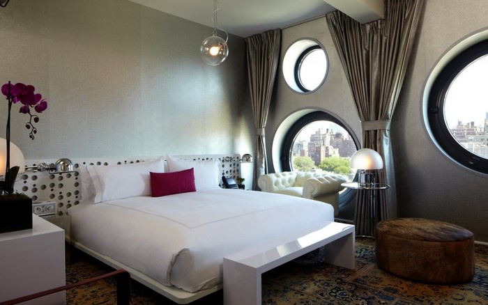 Modern bedroom with unique circular windows and city view