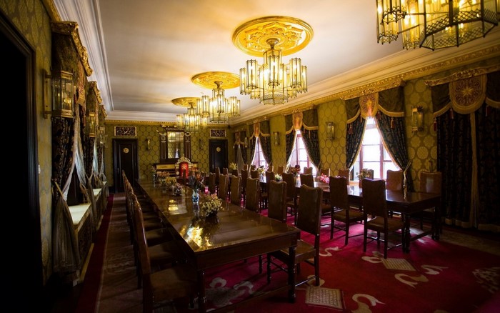 Grand dining hall with long table and chandeliers