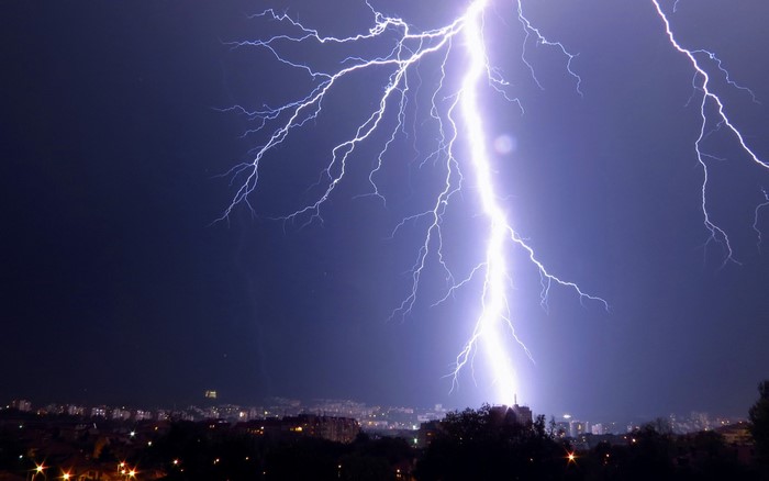 Lightning strike over a city at night