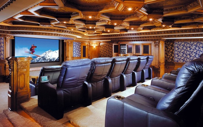 Luxury home cinema with leather recliners and ornate ceiling