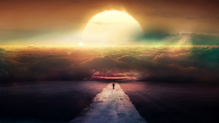 Person walking on a path towards the sun over clouds