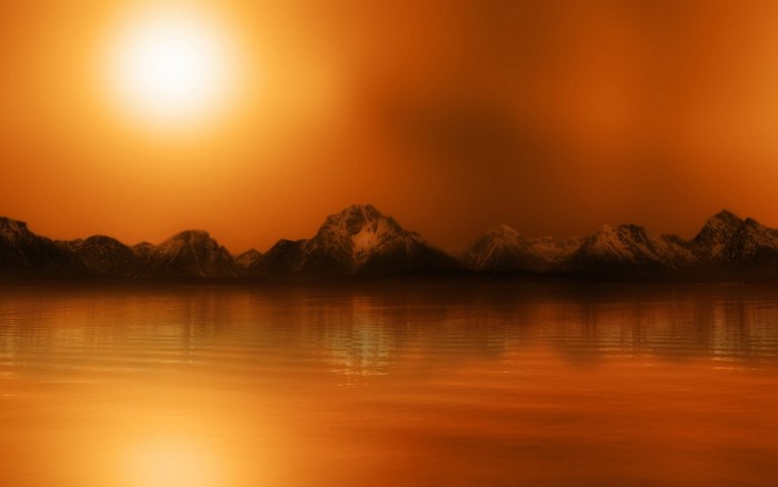 Orange sunset over mountains and lake reflection