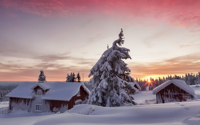 Snowy landscape with houses at sunset