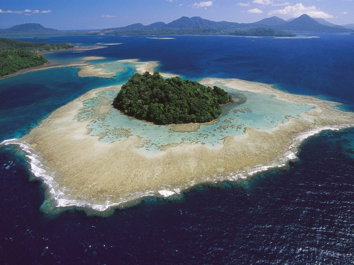 Aerial view of a tropical island with a coral reef lagoon