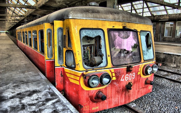 Abandoned train with broken windows at a station