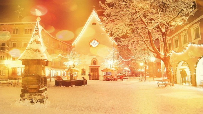 Snowy village square with church and Christmas lights