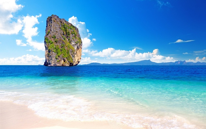 Island rock formation in the ocean near a beach