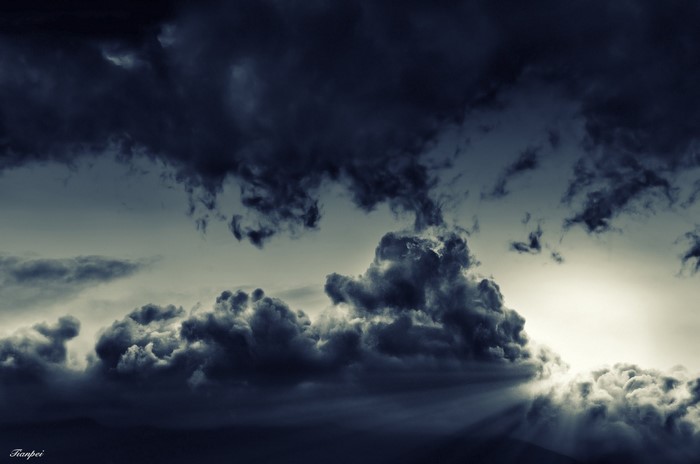 Dark storm clouds with sun rays breaking through