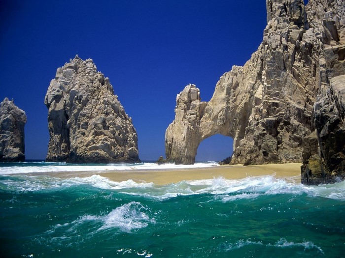 Rocky coast with arch and turquoise ocean waves