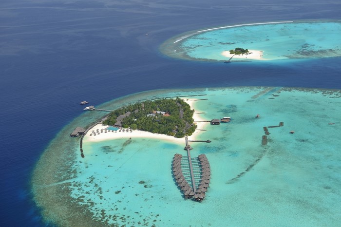 Aerial view of tropical islands and overwater bungalows in a turquoise lagoon