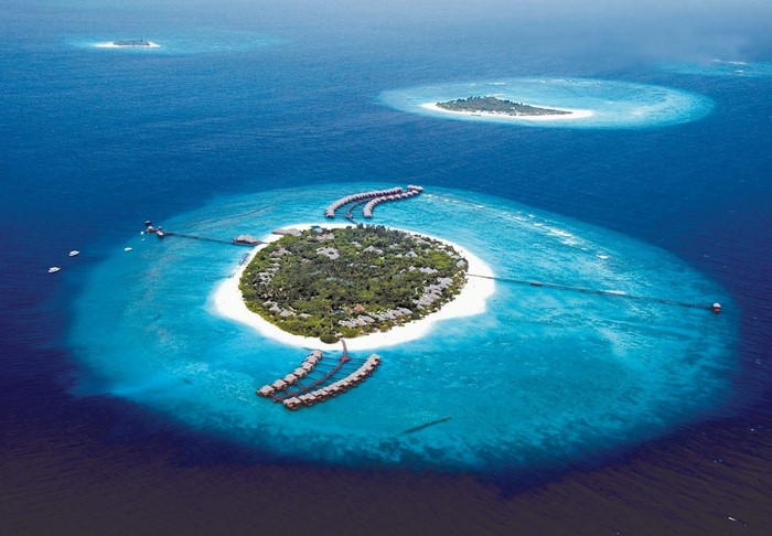 Aerial view of tropical islands and overwater bungalows in the ocean
