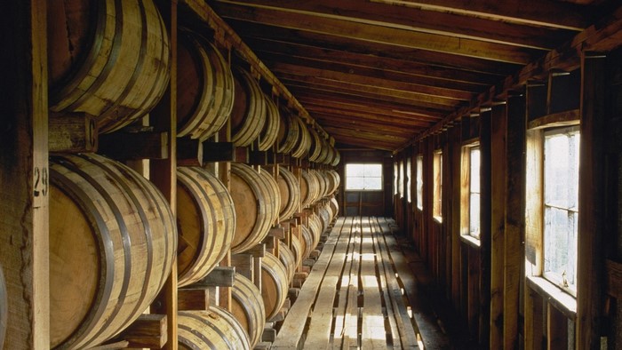 Whiskey barrels stored in a wooden warehouse