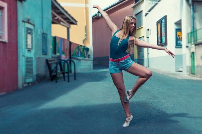 Woman in ballet attire dancing in a street