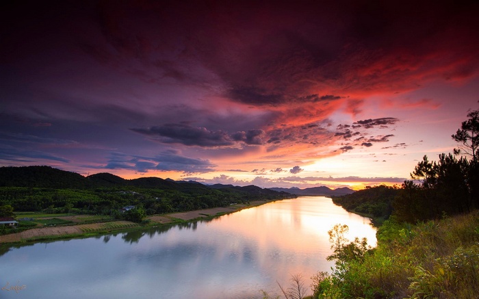 River at sunset with colorful clouds and hills
