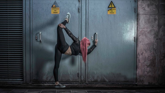 Woman with pink hair performing a dance move