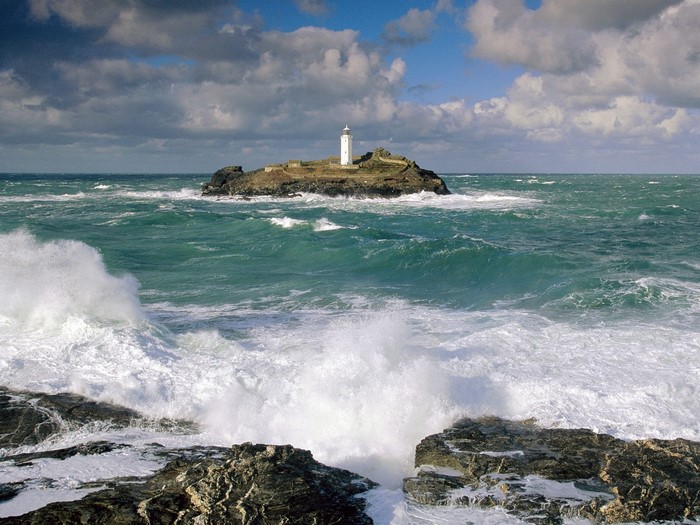Lighthouse on Rocky Island Amid Turbulent Sea