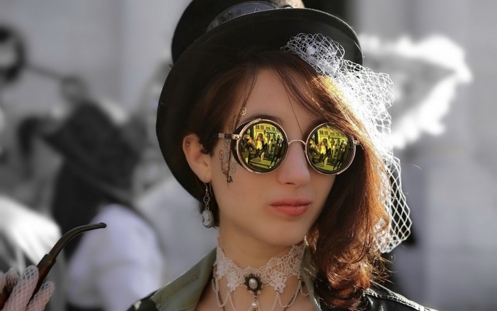 Woman in steampunk attire with top hat and goggles