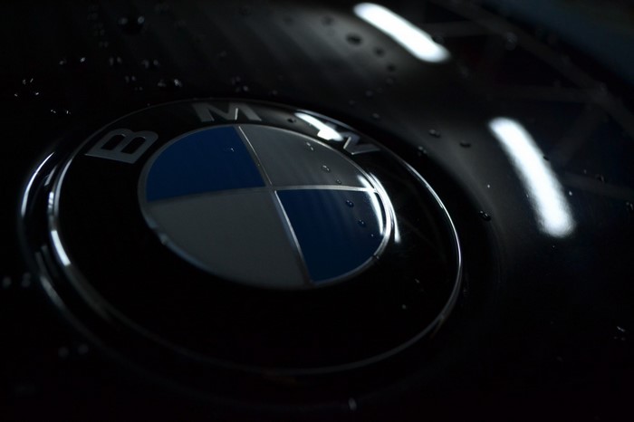 BMW logo on a dark car with water droplets