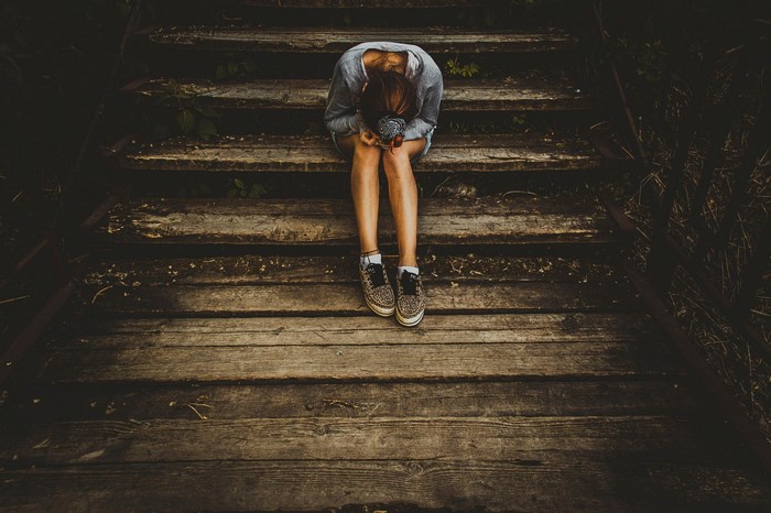 Woman sitting on wooden stairs