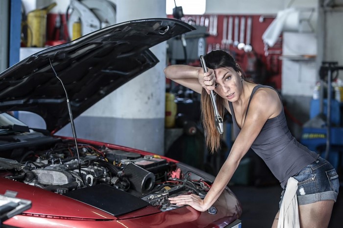 Woman mechanic working on a car engine