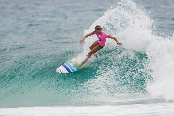 Surfer in pink top riding a wave
