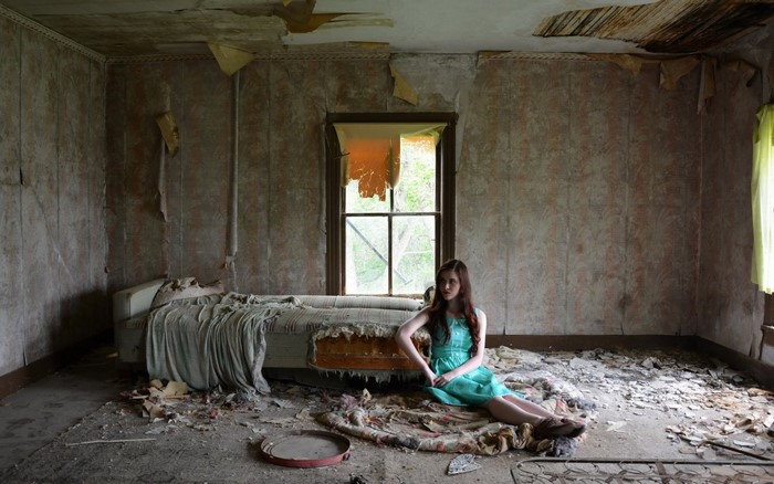 Girl in a dilapidated room with a bed