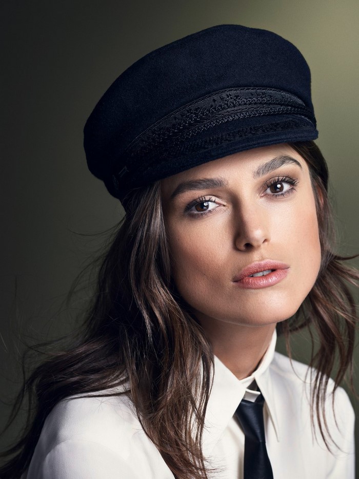 Keira Knightley wearing a black cap and white shirt