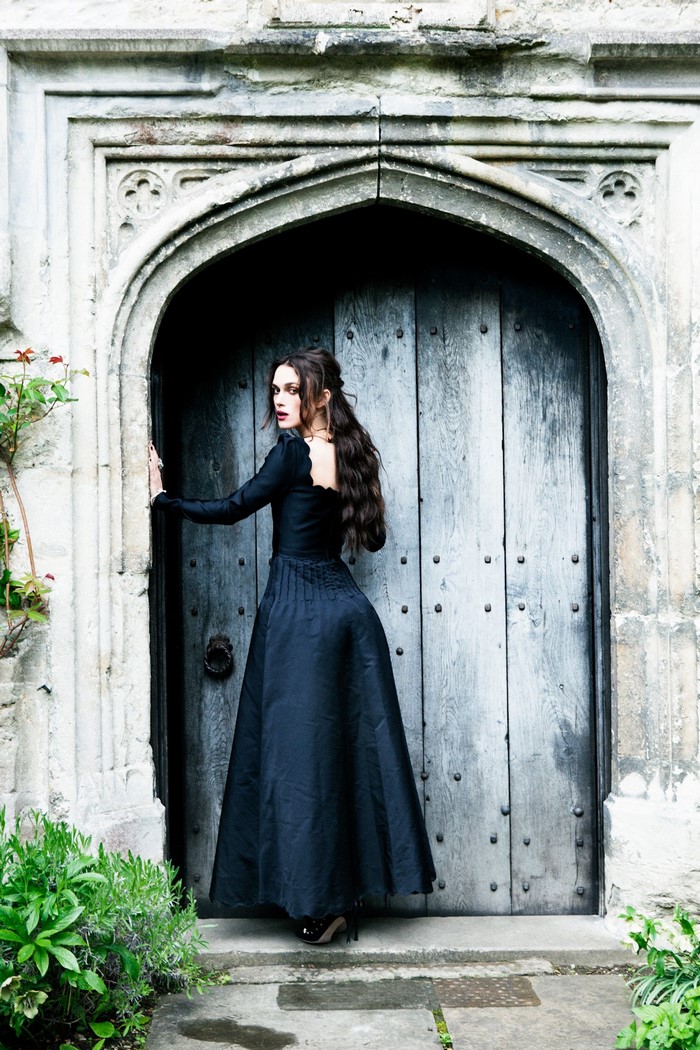 Keira Knightley in a black dress at an arched doorway