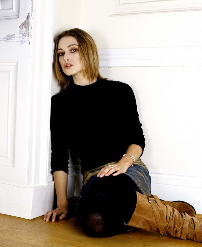 Keira Knightley sitting by a white wall