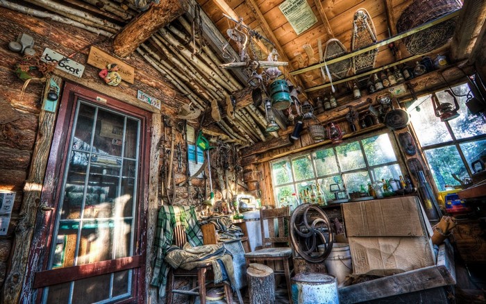 Interior of a rustic log cabin filled with tools and items