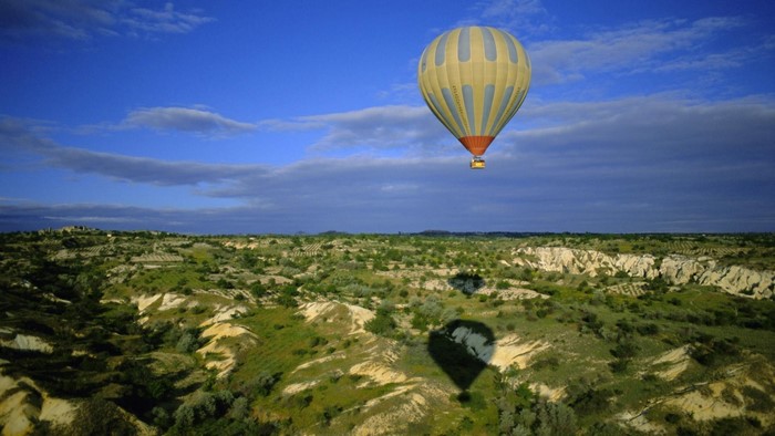 Hot air balloon flying over Cappadocia landscape