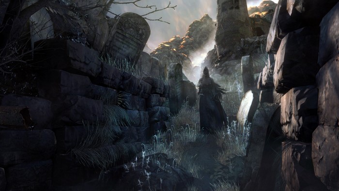 Figure in dark cloak in a rocky graveyard
