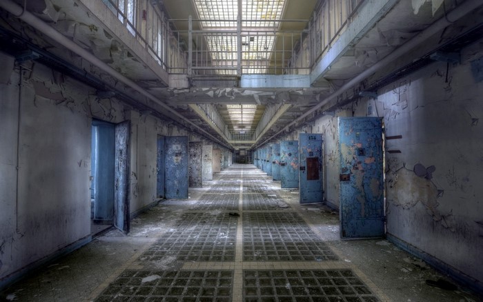 Abandoned prison corridor with cells