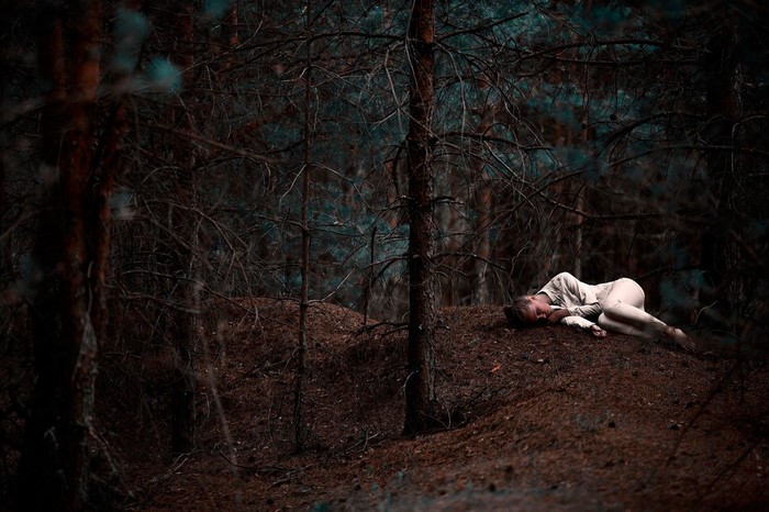 Woman sleeping in a dark forest