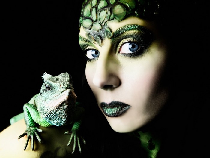 Woman with green makeup and lizard