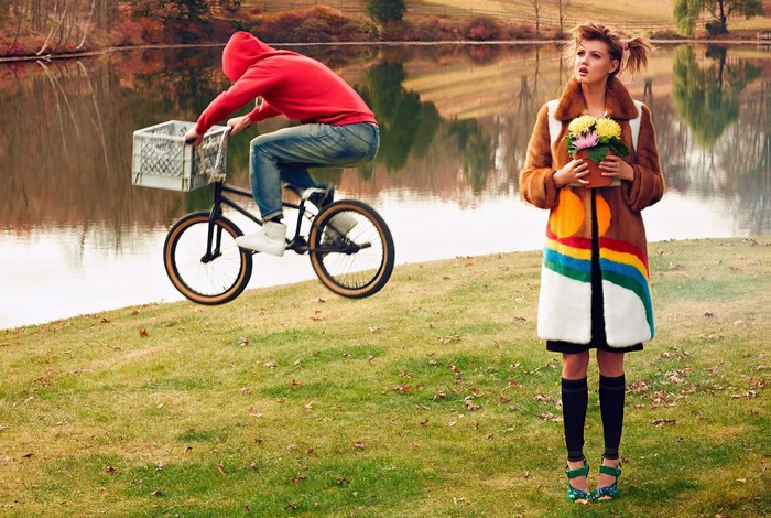 Woman holding flowers and person on bicycle near lake