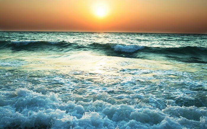 Sunset over the ocean with waves