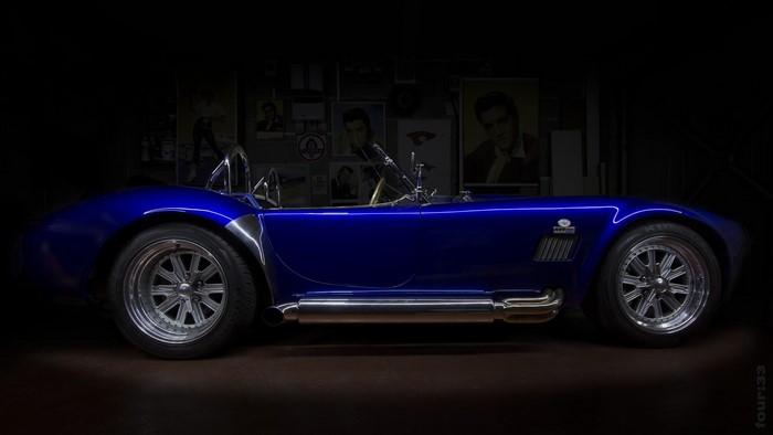 Blue Shelby Cobra sports car with Elvis Presley posters