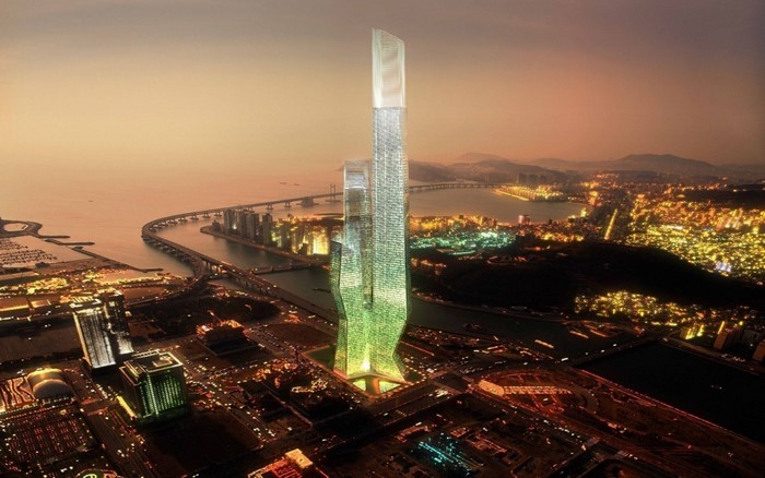 Aerial view of a modern city skyline at dusk with a prominent skyscraper