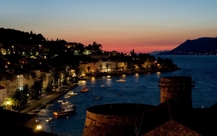 Coastal town at dusk with boats in the bay