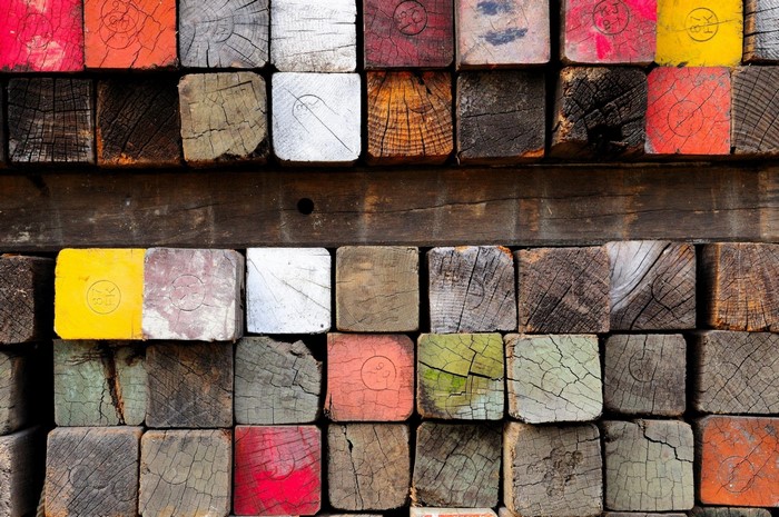 Stacked colorful and weathered wooden beams