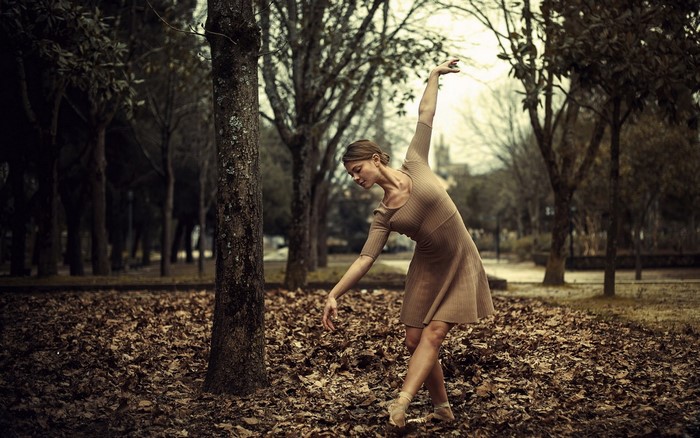 Ballerina dancing in a park during autumn