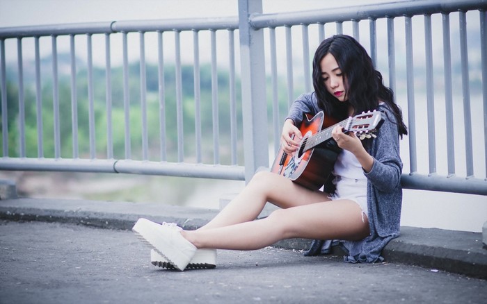Young Woman Playing Guitar Outdoors