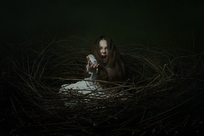 Girl screaming in a nest of branches